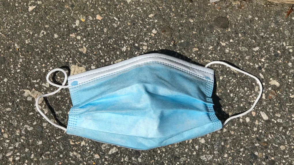 A used protective face mask is seen discarded on the ground in this file photo taken in May, 2020. THE CANADIAN PRESS/Jonathan Hayward