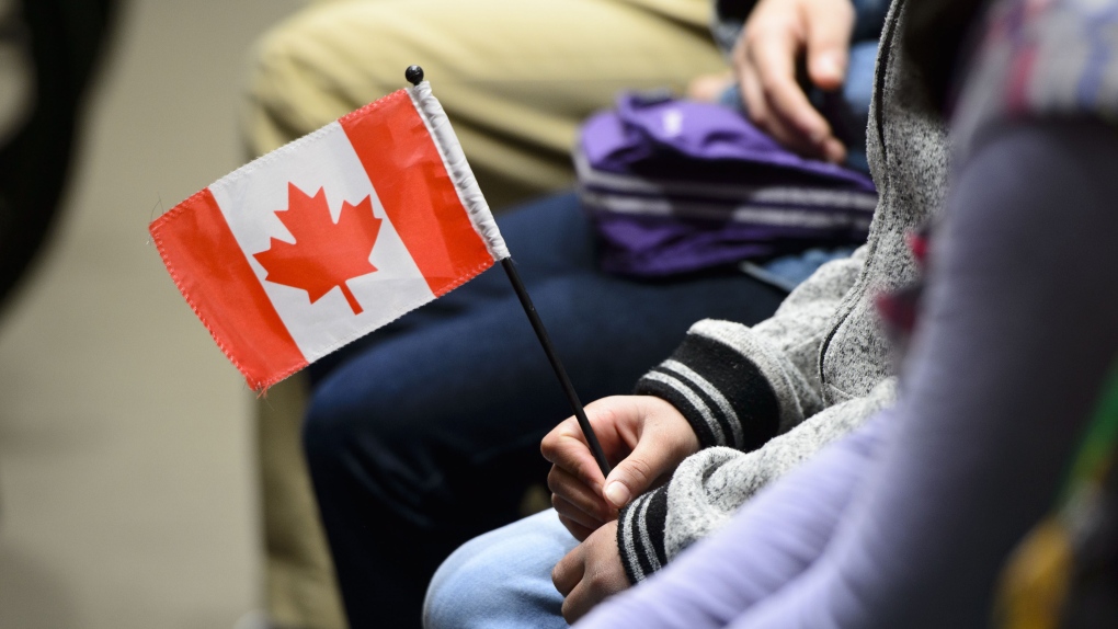 A young new Canadian holds a flag as she takes part in a citizenship ceremony on Parliament Hill in Ottawa on Wednesday, April 17, 2019, to mark the 37th anniversary of the Canadian Charter of Rights and Freedoms. (THE CANADIAN PRESS/Sean Kilpatrick)