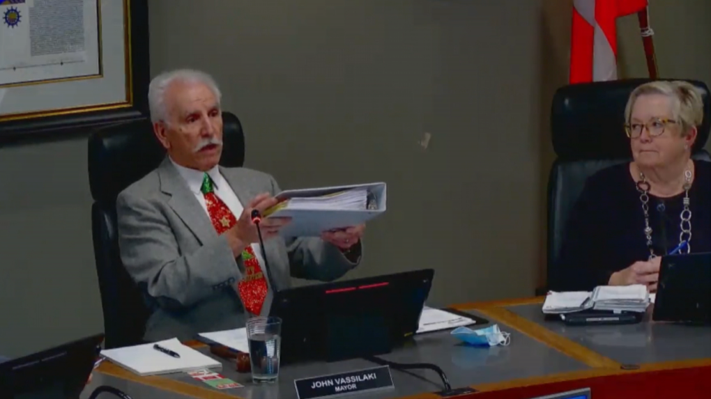 Penticton Mayor John Vassilaki holds up a binder of documents that the B.C. city provided during an ombudsperson's investigation into a 2018 tax sale. 