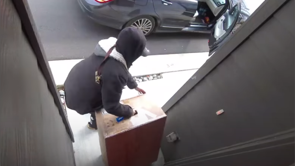 Video released by Burnaby RCMP shows a female suspect taking a package from the doorstep of a home. 