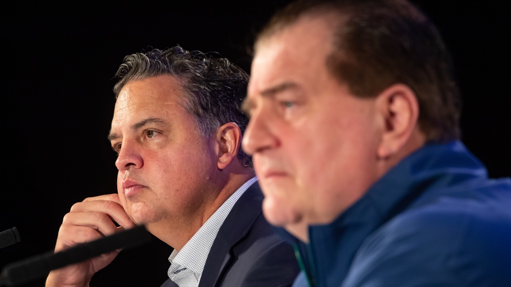 Vancouver Canucks head coach Travis Green, back left, and general manager Jim Benning listen during a news conference ahead of the NHL hockey team's training camp, in Vancouver, on Wednesday, September 22, 2021. THE CANADIAN PRESS/Darryl Dyck 