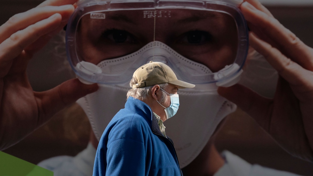 A man wears a protective face mask to help prevent the spread of COVID-19 as he walks past a billboard from the Vancouver General Hospital in Vancouver Thursday, April 8, 2021. THE CANADIAN PRESS/Jonathan Hayward