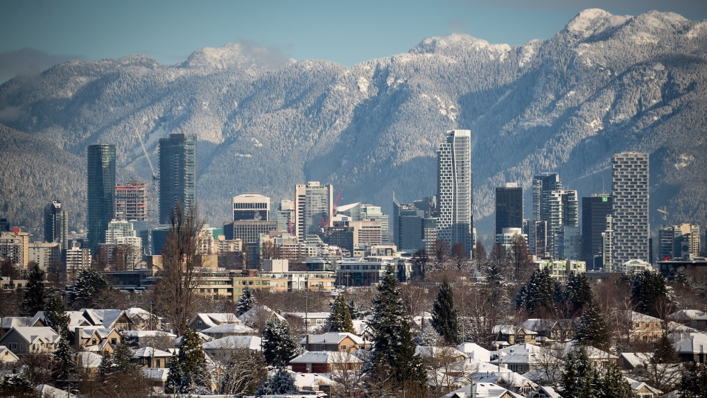 Snow-covered houses and the downtown Vancouver skyline are seen with the North Shore mountains in the distance on Thursday, December 30, 2021. THE CANADIAN PRESS/Darryl Dyck 
