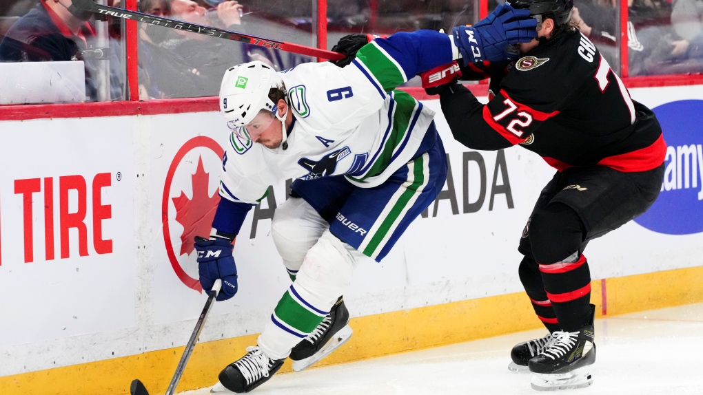 Vancouver Canucks centre J.T. Miller (9) shoves his glove in the face of Ottawa Senators defenceman Thomas Chabot (72) during third period NHL action in Ottawa on Wednesday, Dec. 1, 2021. (Sean Kilpatrick / THE CANADIAN PRESS)
