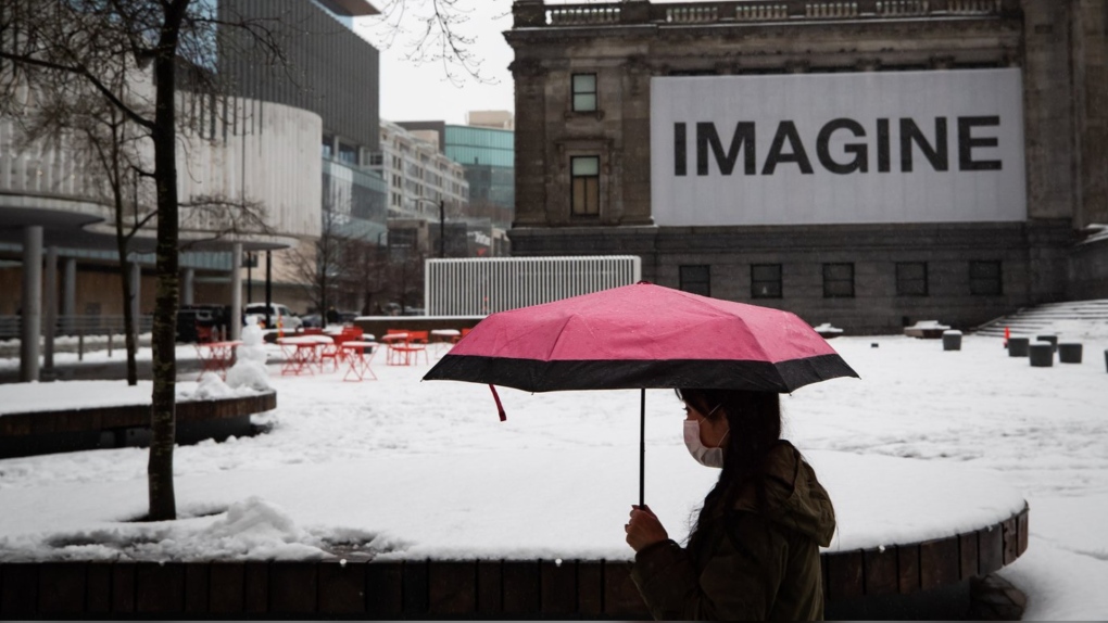 A person walks past the snow-covered square outside the Vancouver Art Gallery in Vancouver, B.C., Thursday, Jan. 6, 2022. Most of British Columbia is subject to warnings and special weather statements as Environment Canada forecasts blustery and snowy conditions this weekend. THE CANADIAN PRESS/Darryl Dyck