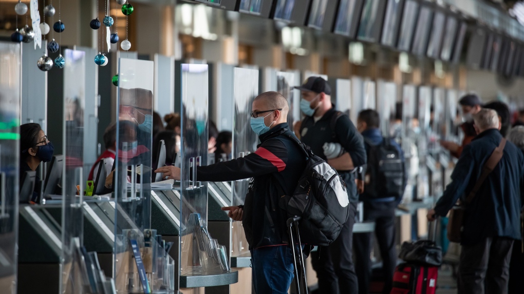 Passengers check in for flights to the U.S. at Vancouver International Airport, in Richmond, B.C., on Thursday, December 2, 2021. THE CANADIAN PRESS/Darryl Dyck 