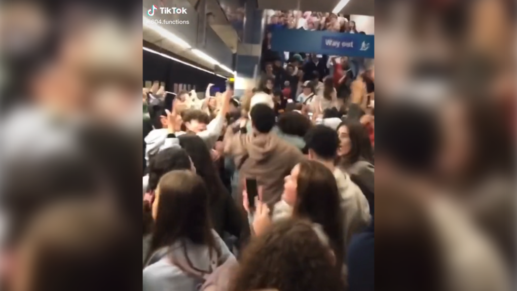 People jump up and down on a crowded SkyTrain platform in a TikTok video posted by user @605.functions. 
