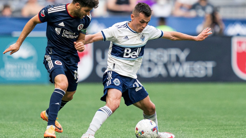 Vancouver Whitecaps' Andres Cubas, right, fights off the challenge of New England Revolution's Carles Gil during second half MLS soccer action in Vancouver, BSunday, June 26, 2022. THE CANADIAN PRESS/Rich Lam 