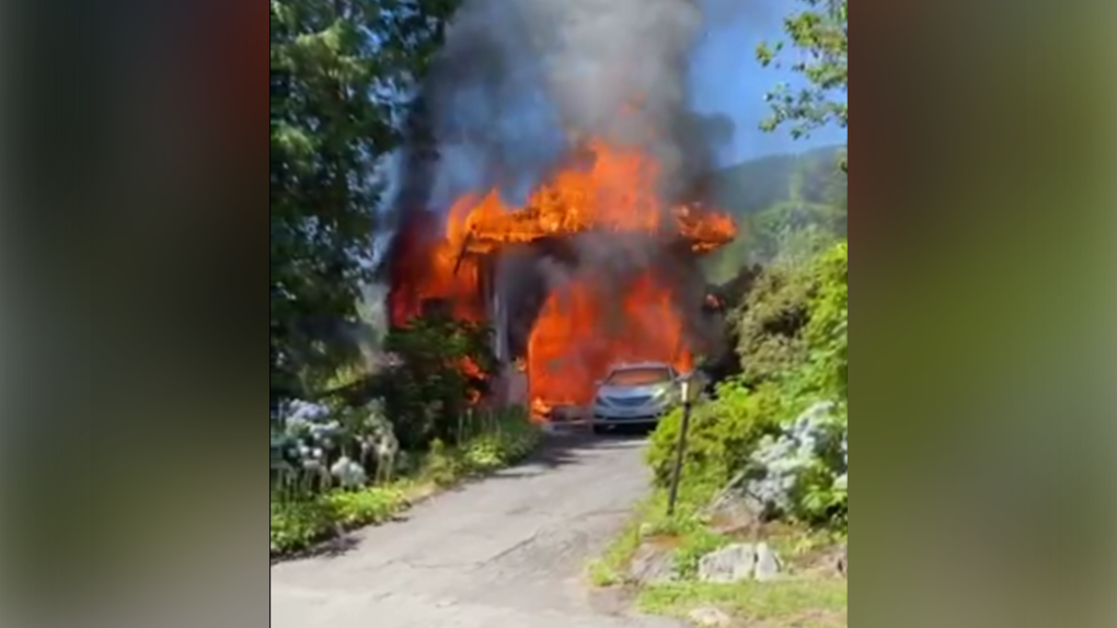 This image from a video submitted by Cate Brown shows a house on fire in West Vancouver on Aug. 7, 2022. 