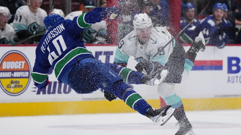 Vancouver Canucks' Elias Petterson (40), of Sweden, and Seattle Kraken's Ryan Donato (9) collide during overtime NHL hockey acton in Vancouver, on Thursday, September 29, 2022. THE CANADIAN PRESS/Darryl Dyck