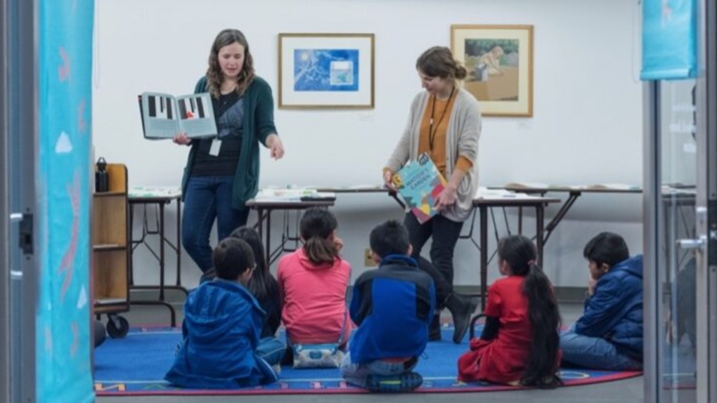 Two librarians with the Vancouver Public Library's "Alligator Pie" program are seen reading to children in a daycare centre. The program is one of three that will benefit from a $150,000 donation a Hong Kong-based philanthropic foundation plans to dole out over the next three years. (VPLF)
