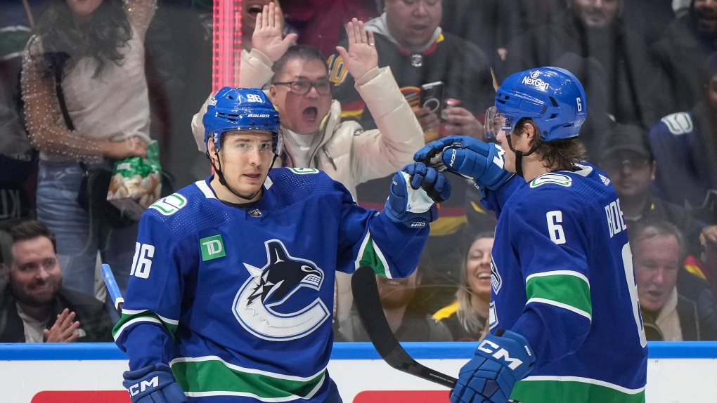 Vancouver Canucks' Andrei Kuzmenko, left, and Brock Boeser celebrate Kuzmenko's goal against the Vegas Golden Knights during the third period of an NHL hockey game in Vancouver, on Thursday, November 30, 2023. THE CANADIAN PRESS/Darryl Dyck