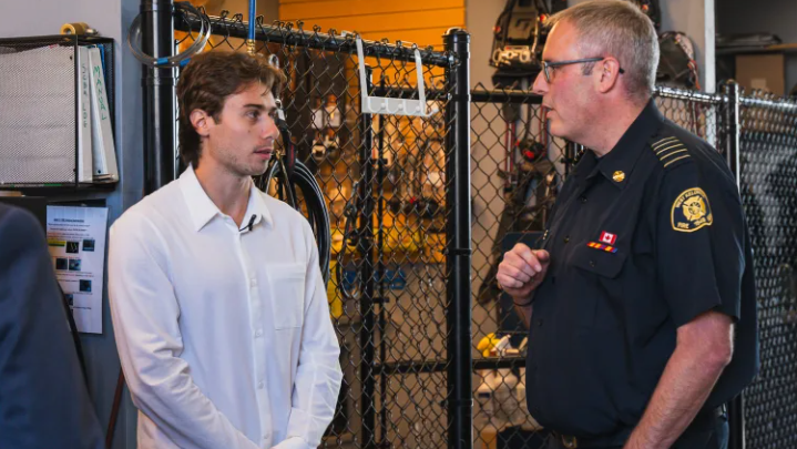 Vancouver Canucks Captain Quinn Hughes speaks with West Kelowna Fire Chief Jason Brolund during a visit in September. (Image credit: Canucks Sports and Entertainment) 