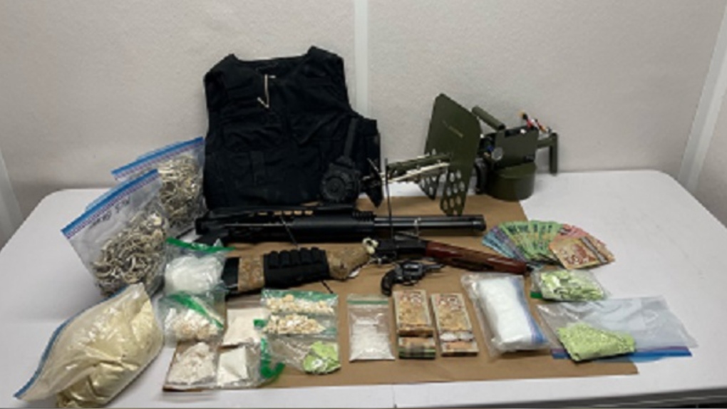 A handout photo from the Upper Fraser Valley Regional District shows drugs, guns and cash that Chilliwack RCMP seized while executing search warrants at two properties on March 14, 2023. 