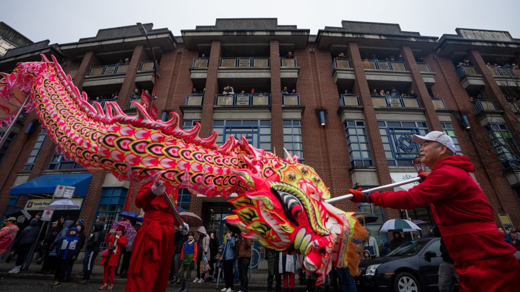 A dragon dance is performed as people watch from above during the 50th annual Spring Festival Parade through Chinatown for the Lunar New Year in Vancouver, B.C., Sunday, Feb. 11, 2024. THE CANADIAN PRESS/Ethan Cairns