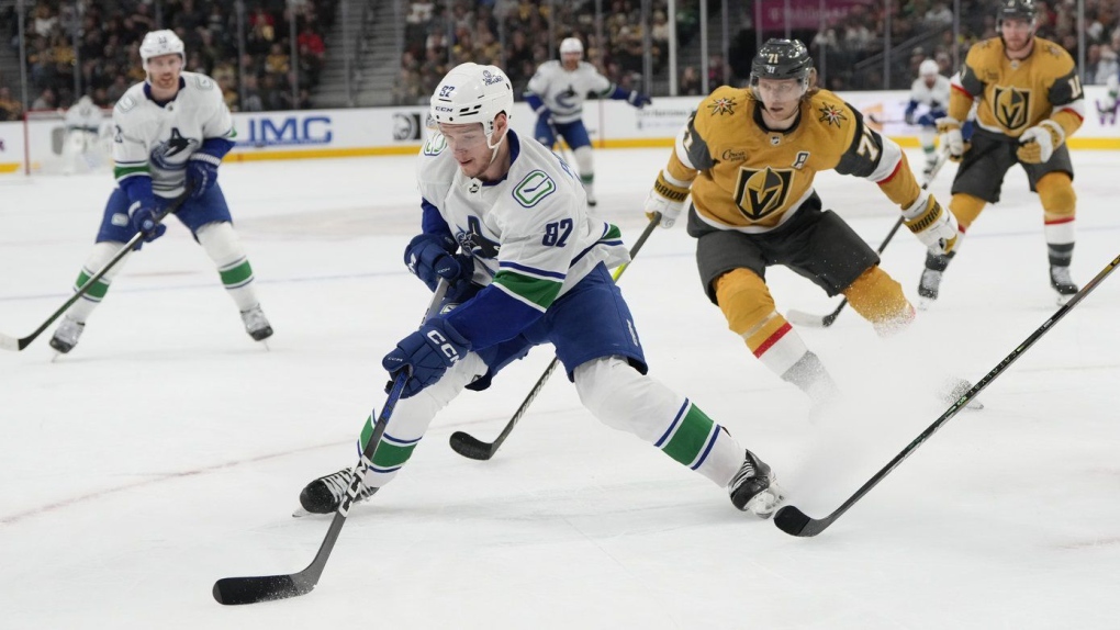 Vasily Podkolzin (92) moves the puck against Vegas Golden Knights center William Karlsson (71) during the first period of an NHL hockey game, in Las Vegas, Thursday, March 7, 2024. THE CANADIAN PRESS/AP-Lucas Peltier